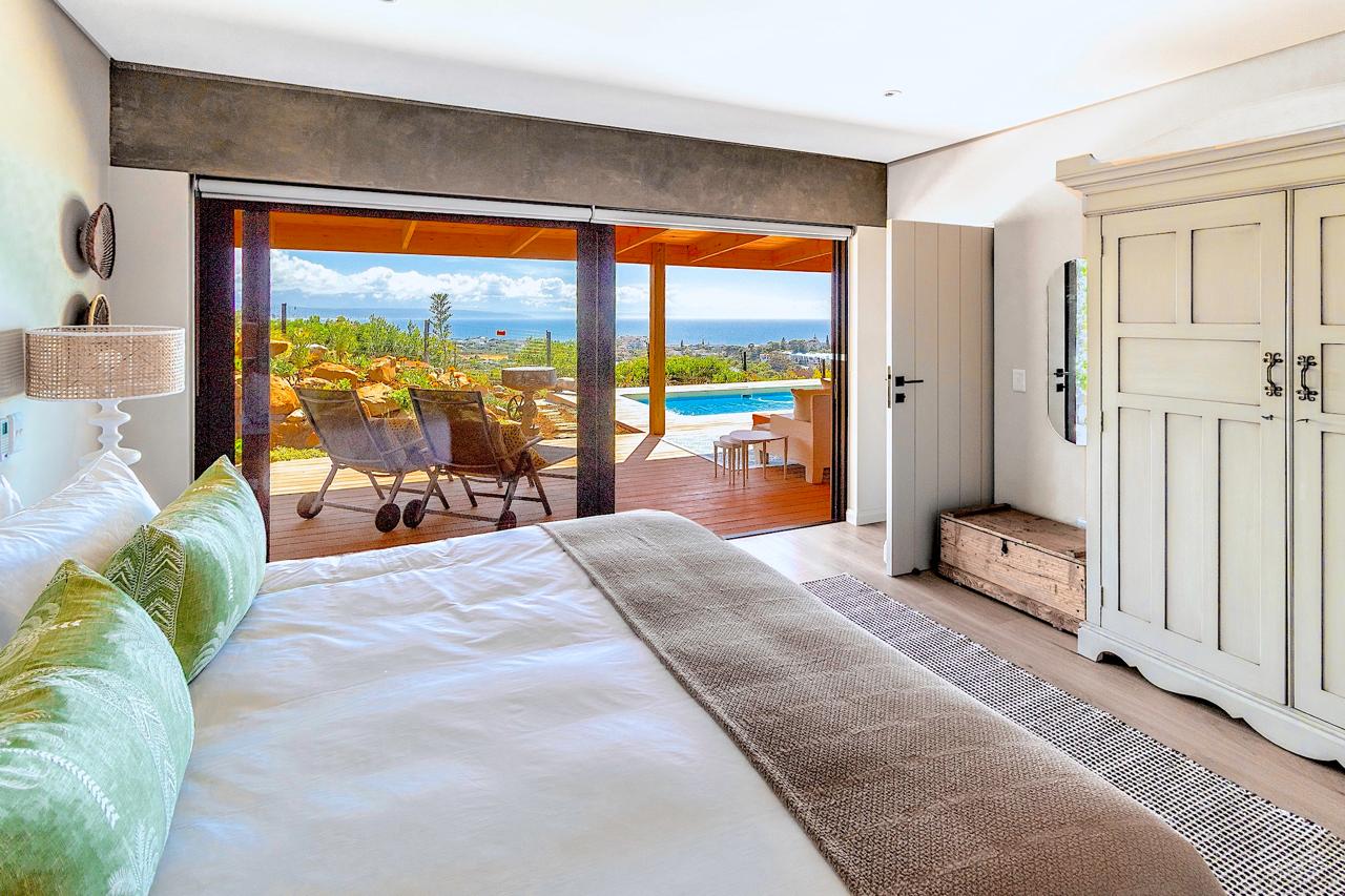 Bedroom with green accent pillows and stunning pool views