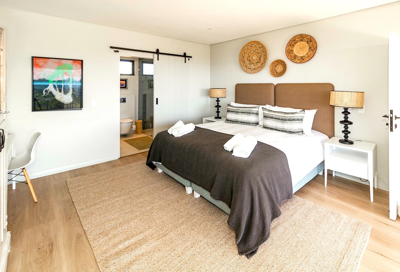 Bedroom with barn door, woven basket wall decor, and ensuite bathroom