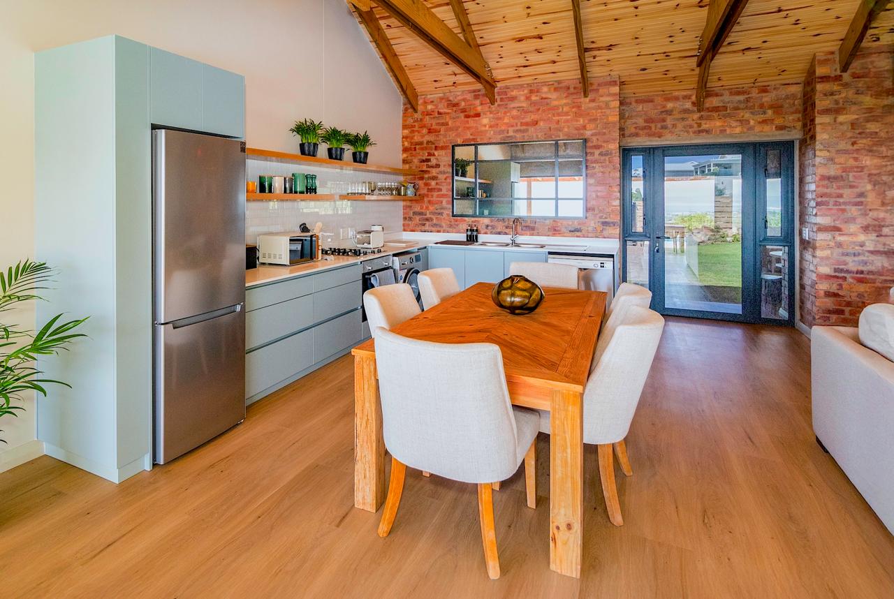 Modern kitchen with mint cabinetry and exposed brick wall
