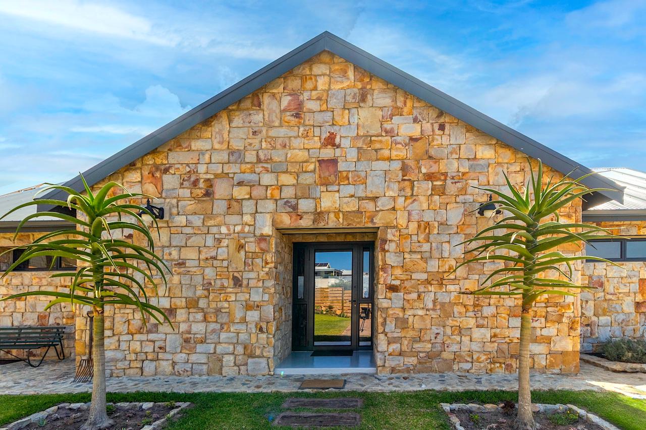 Beautiful stone facade entrance with warm golden tones and palm trees