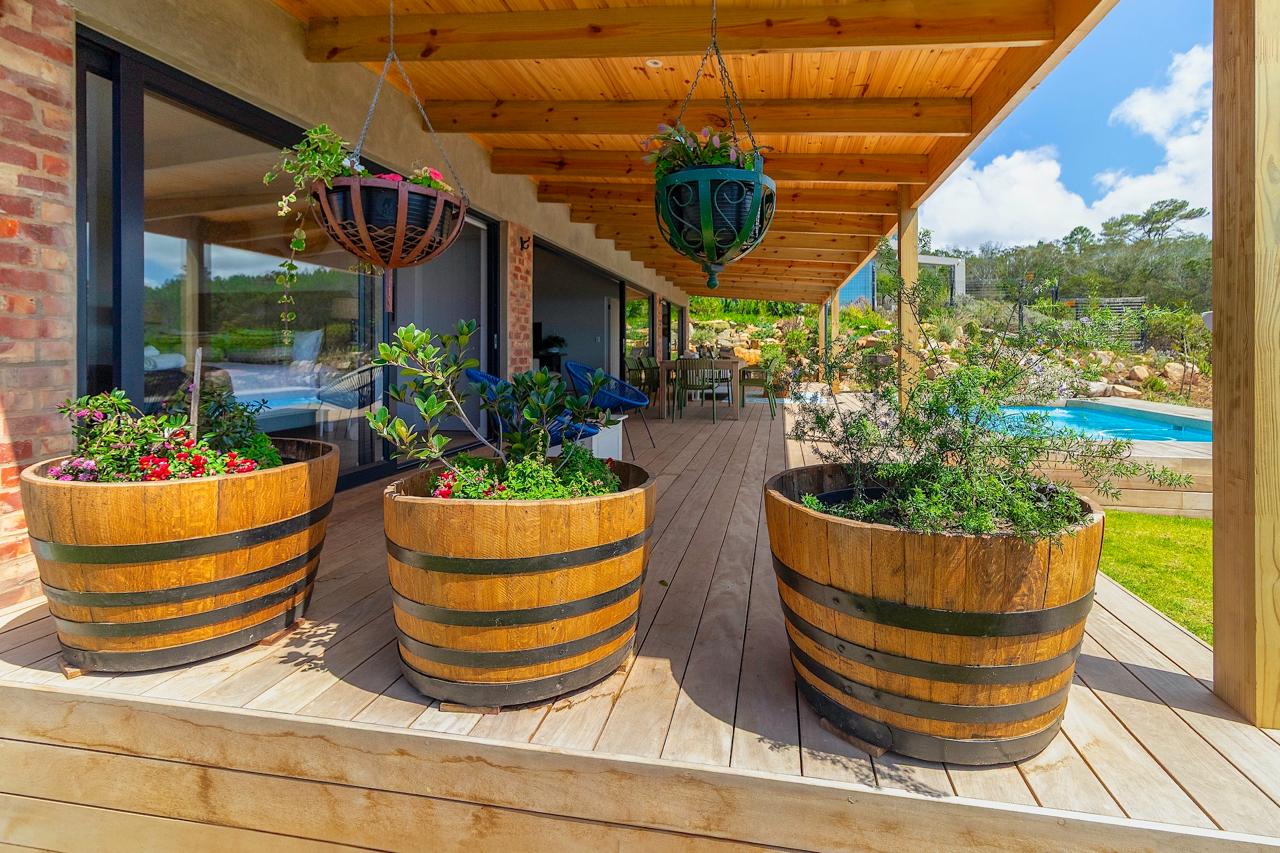 Covered patio with wooden decking and wine barrel planters